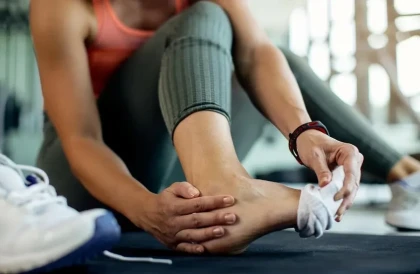 woman examining her foot & ankle during workout