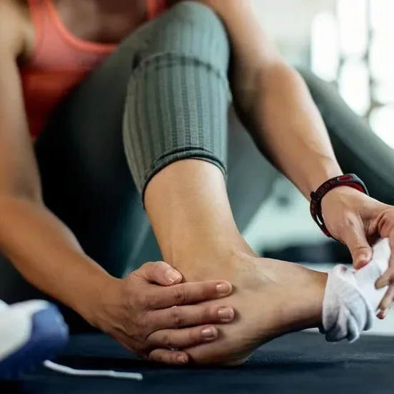 woman examining her foot & ankle during workout