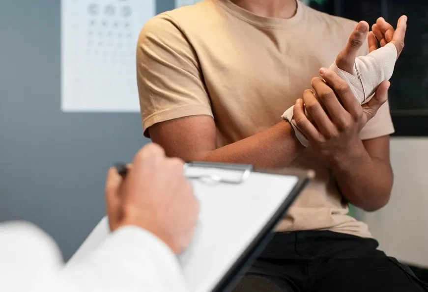 Doctor assessing patient's broken wrist