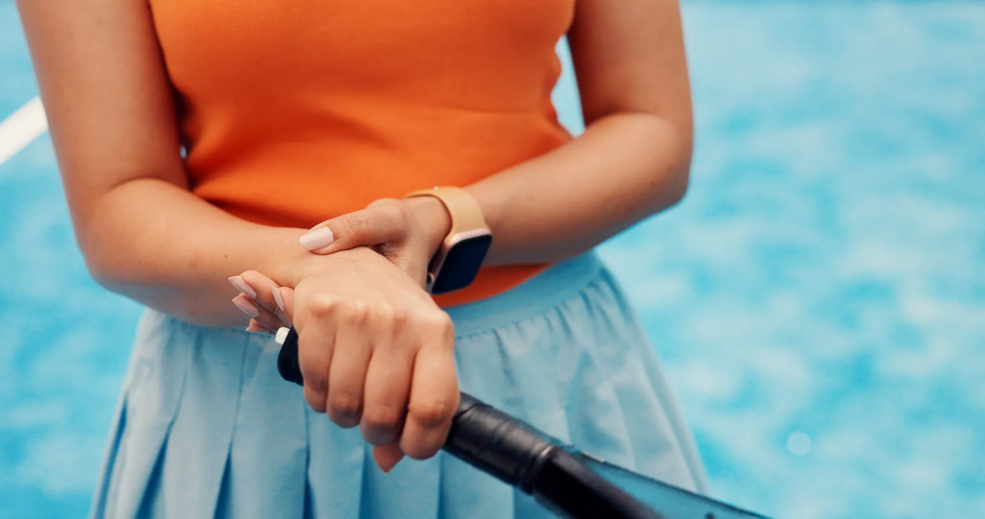 female tennis player holding injured wrist