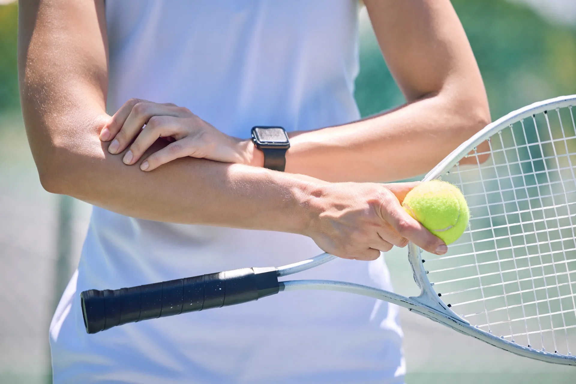 up-close of woman playing tennis with arms bent